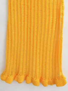 Details des gelben Strickkleids mit Hohlstruktur und Rüschensaum in der Makroansicht