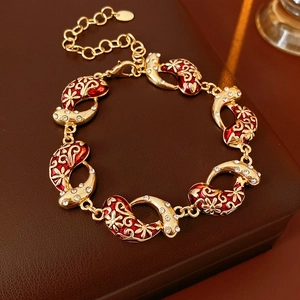 Detail of vintage gold bracelet with red enamel and sparkling zircon accents