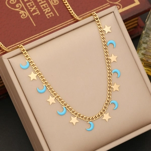 Goldkette mit Stern und hellblauem Mondanhänger auf einer beigen Schmuckschatulle