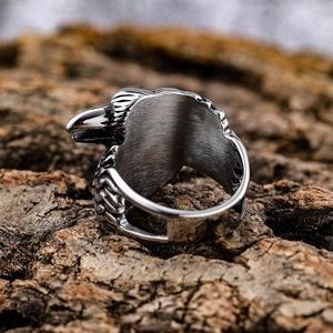 Vintage double eagle head stainless steel ring displayed on a natural tree bark background