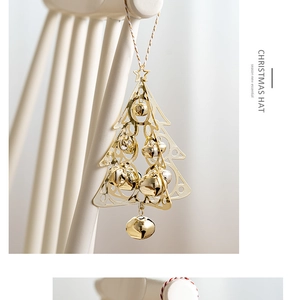 Detail of golden hollow metal Christmas tree ornament with bells on a white background