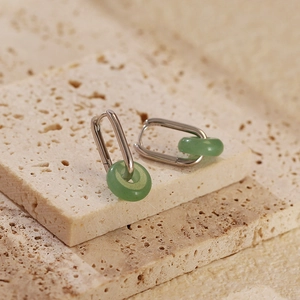 Détail de boucles d'oreilles en argent s925 avec aventurine verte sur travertin