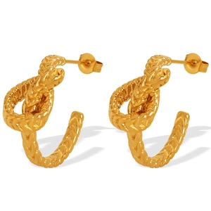 Boucles d'oreilles nœuds torsadés dorés avec texture corde sur fond blanc pur