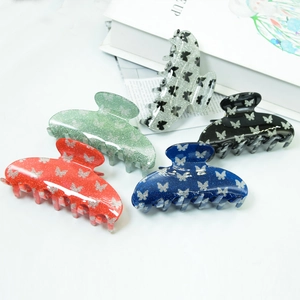 Glittery butterfly pattern PVC hair claws in five colors on a minimalist background