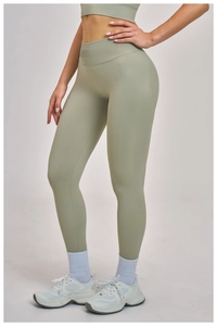 Detail of sage green seamless yoga pants with a wide ribbed high waistband and premium texture