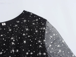 Dettaglio dell'abito in rete nera con stelle, scollatura, maniche e etichetta taglia S
