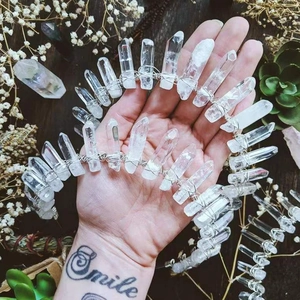 Detailed view of white crystal quartz crown handmade with wire on dark wood background