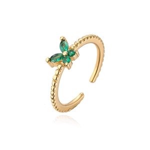 Detailed macro of gold plated butterfly ring with green marquise cubic zirconia stones