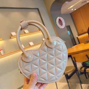 Detail of heart-shaped quilted jelly bag in nude beige with glossy PVC finish