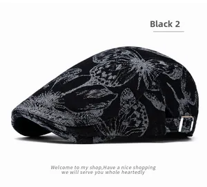 Detail of adjustable metal buckle on black denim ivy cap with silver floral pattern