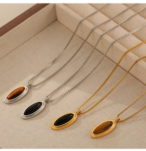Detailed view of vintage titanium necklaces with tiger eye and shell shell pendants in a tray