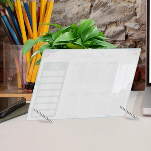 Acrylic weekly planner board with metal stands on a desk for office organization