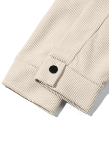 Detailed close-up of beige corduroy sleeve cuff with a minimalist black button