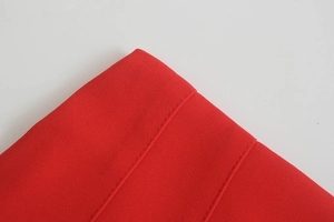 Vista macro di pantaloni rossi a vita alta che mostrano la trama del tessuto e le cuciture