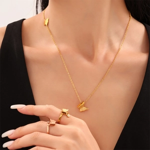 Elegante 18k vergulde matte vlinder sieradenset met ketting en ringen gedragen door model