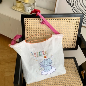 Detail of cute elephant embroidery on white Oxford cloth tote with pink shoulder strap
