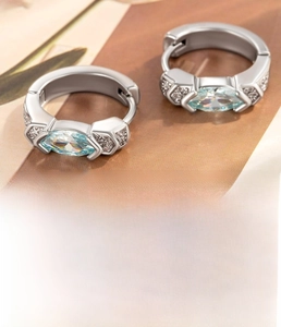 Détail macro d'une créole en cuivre argenté avec zircon bleu clair marquise et dimensions