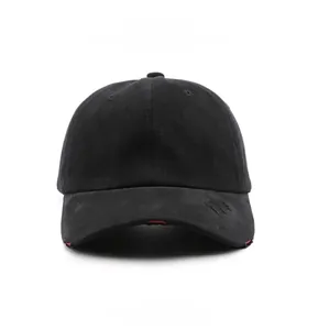 Detail der abgenutzten Krempe einer schwarzen Vintage-Basecap mit roter Kontrastpaspel