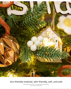 Close-up of wooden house ornament with warm LED lights on a pine Christmas tree
