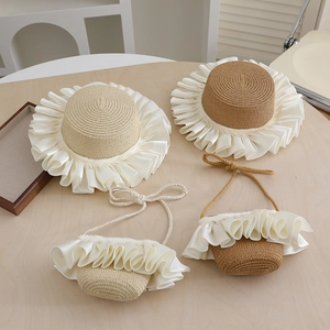 Detail of straw hat and matching bag set with white satin ribbon edges for summer beach wear