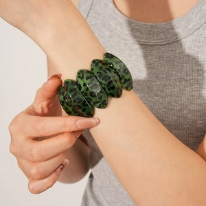 Detailed macro of green leopard print resin chain bracelet with marble texture detail