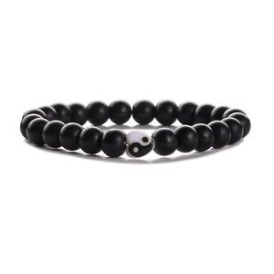 Matte black beaded bracelet set featuring a yin yang heart charm on white background