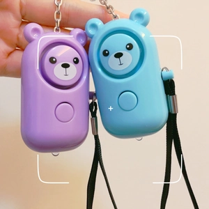 Close-up of cute bear-shaped personal safety alarms in purple and blue with keychains