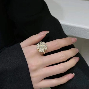 Macro detail of rotating four-leaf clover ring with shimmering zircon insets on a golden band