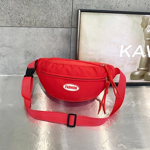 Dettaglio della borsa a tracolla in nylon rosso con patch fashion e fibbia regolabile