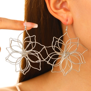 Macro shot of silver hollow wire floral earrings showcasing intricate woven metal craftsmanship