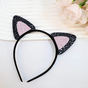 Detailed view of cat ear headband with pink and black glitter on a white surface