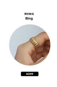 Dettaglio di un anello largo placcato oro a strisce con design ondulato sulla mano