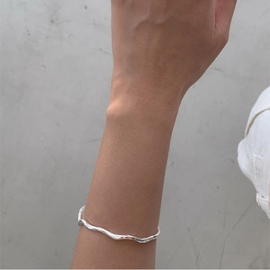 Minimalist 925 sterling silver Mobius twisted open bangle on a female wrist