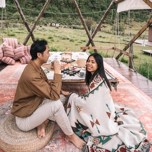 Close-up of bohemian picnic blanket with geometric patterns and fringe in outdoor camp