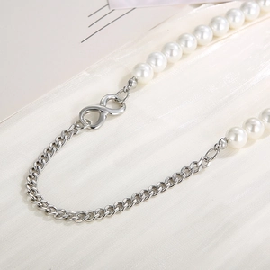 Close-up of pearl and silver curb chain necklace with minimalist infinity connector