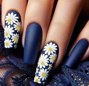 Macro shot of matte blue coffin press-on nails featuring white daisy floral patterns