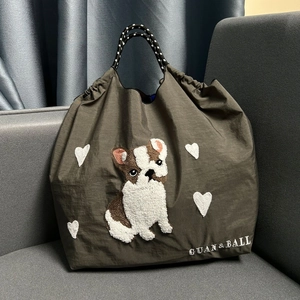 Detail of cute dog embroidery and white hearts on olive green nylon tote bag