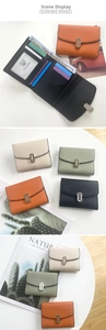 Detail of short tri-fold leather wallet with multiple card slots and metal buckle