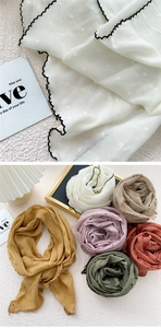 Detail of multi-colored semi-circle scarves with textured dot pattern and scalloped edges