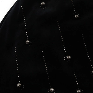 Macro detail of rhinestone patterns and silver beads on a black fleece beanie