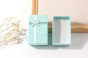 Close-up of light blue jewelry gift box with elegant ribbon bow and interior jewelry slot