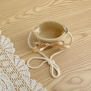 Détail d'un sac bandoulière en paille pour fille avec nœud floral et fermeture éclair