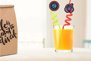 Close-up of colorful 80s music theme spiral straws with decorative party discs