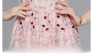 Détail de la taille sur robe en tulle rose avec broderies florales et bords en dentelle