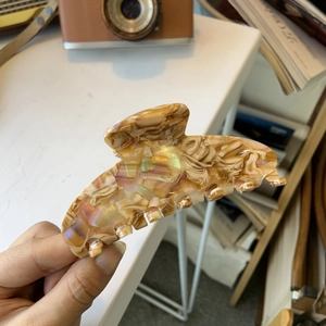 Detailed view of large acetate hair claw clip with iridescent marble texture and shimmer
