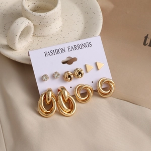 Detail view of 6-piece gold earring set with pearls and rhinestones on aesthetic backdrop