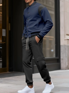 Dettaglio dei pantaloni cargo neri da uomo con tasca laterale e trama in maglia