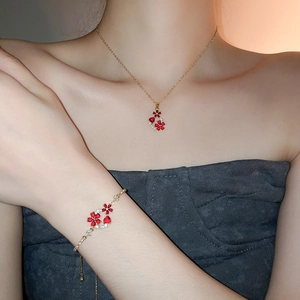 Macro view of 18k gold plated jewelry set with red flowers and tiny diamonds on a model