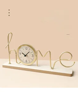 Detail of minimalist 'home' letter metal clock with golden finish and wooden base