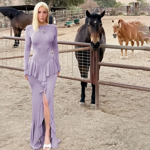 Elegant purple maxi dress with ruffle hem and high slit detail in a scenic outdoor setting